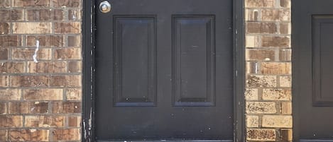 A black door with a number plate reading 9258, a mailbox, and a doormat.