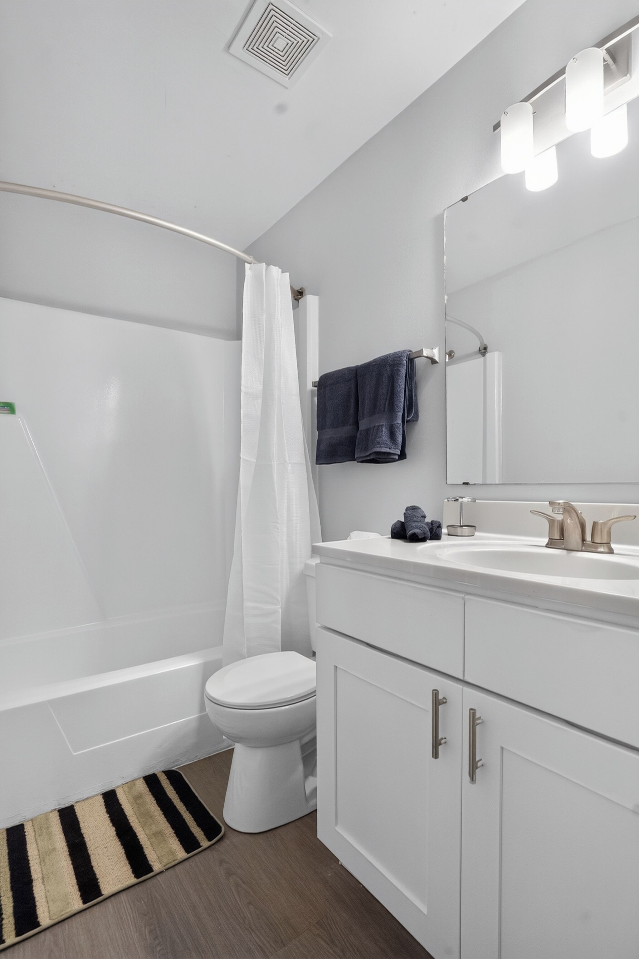 A modern bathroom with a bathtub, toilet, and vanity.