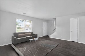 A modern living room with a sofa, a coffee table, and a patterned rug. - Spacious Townhome Designed for Relaxing Stays (Indianapolis)