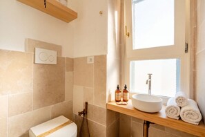 A bathroom with a toilet, a sink, and a shower.