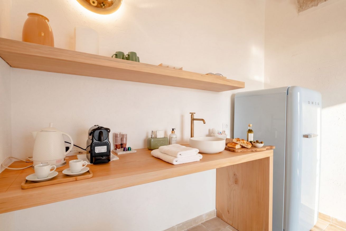 Eine moderne Küchenzeile mit Kaffeemaschine, Wasserkocher und Teekocher auf der Arbeitsfläche.