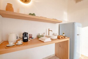 Eine moderne Küchenzeile mit Kaffeemaschine, Wasserkocher und Teekocher auf der Arbeitsfläche.