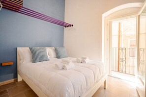 A hotel room with a bed, pillows, and towels.