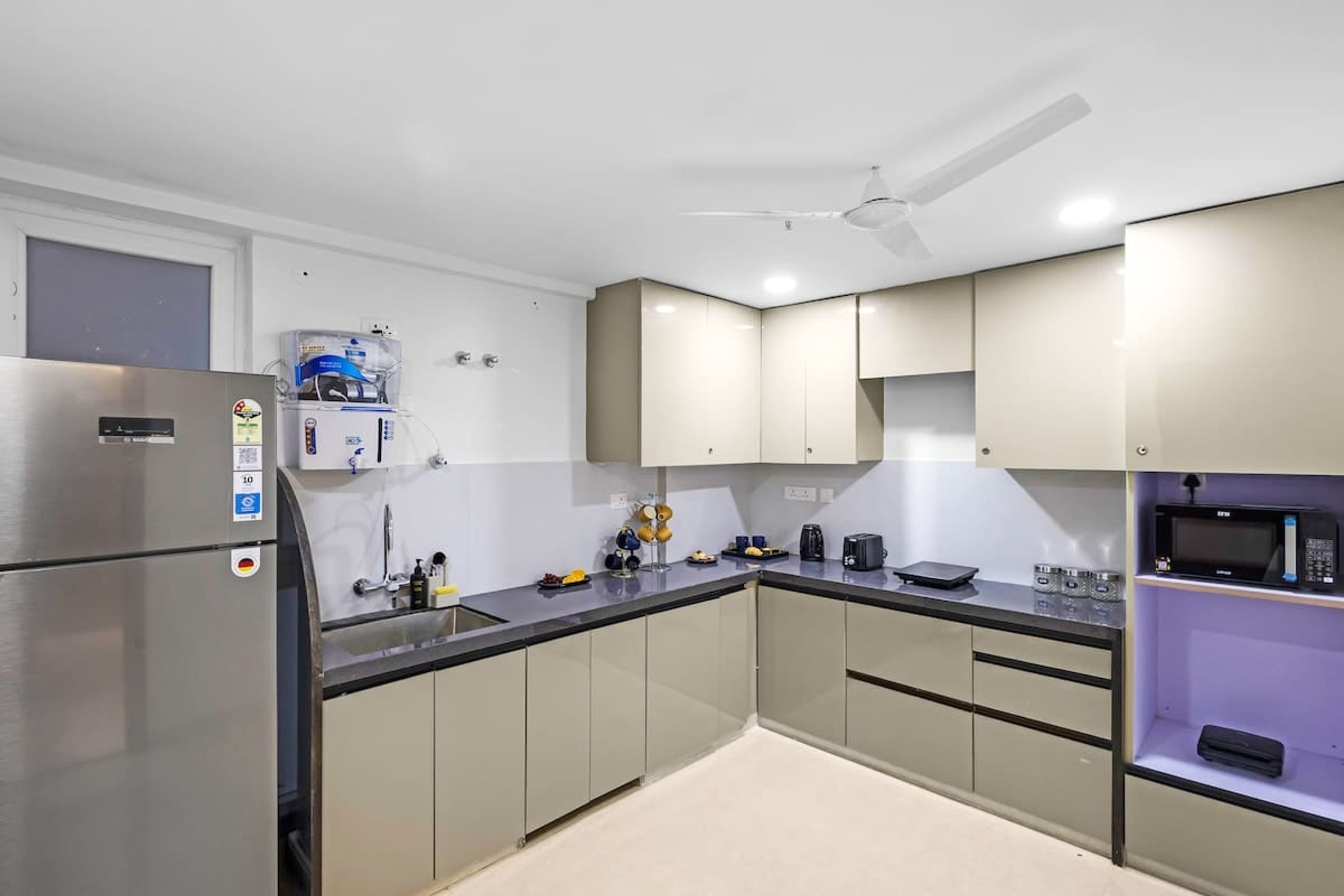 Una cocina moderna con electrodomésticos de acero inoxidable, horno empotrado y microondas.