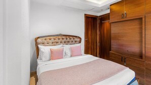 Une chambre à coucher avec un lit, une armoire en bois et un ventilateur de plafond.