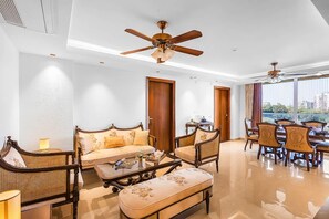 A spacious living area with a sofa, chairs, a dining table, and a ceiling fan. - The Majestic Crown - 2bhk Luxury Home by Viraalay (Jaipur)