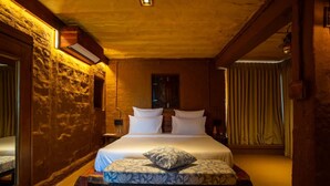 Una camera da letto con un letto, un comodino, uno specchio e una finestra con tende.