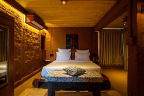 A bedroom with a bed, a bedside table, a mirror, and a window with curtains. - Anavya- 3BR Chilli Farm Villa Near Jodhpur Osian (Tivari)
