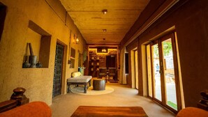 A corridor with a bench, a table, and a large window on the right.