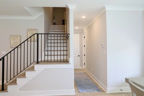A staircase with a black railing, white walls, and a wooden floor. - "Sweet Home Mississippi" by OVR (Oxxford)