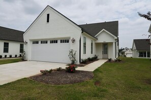 A single-story house with a garage, a front porch, and a well-maintained lawn. - "Sweet Home Mississippi" by OVR (Oxxford)