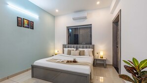 A modern bedroom with a large bed, bedside tables, a window with a view, and a plant.