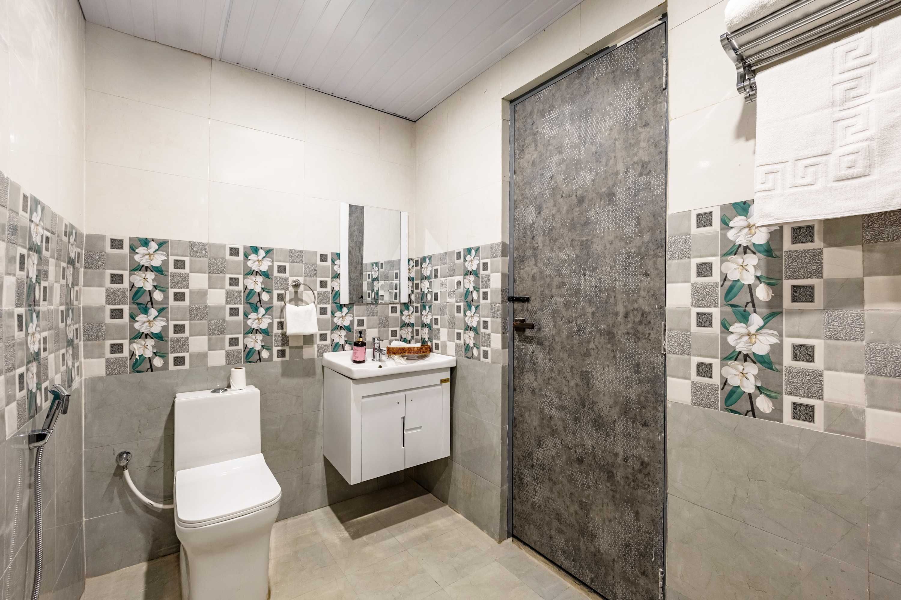 Une salle de bain avec des toilettes, un lavabo et une douche.