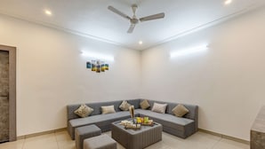 A modern living room with a grey sectional sofa, a coffee table, and a ceiling fan.