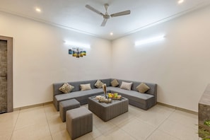 A modern living room with a grey sectional sofa, a coffee table, and a ceiling fan.