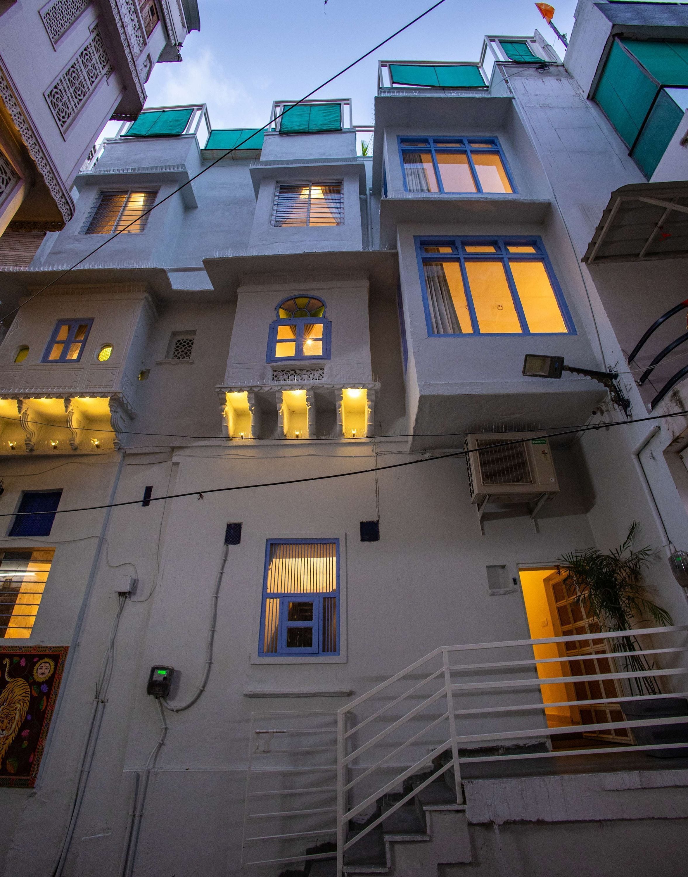 A multi-story building with balconies, a staircase, and a visible air conditioning unit.