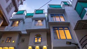 Un immeuble à plusieurs étages doté de balcons, d’un escalier et d’un appareil de climatisation apparent.