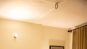 Une chambre d’hôtel avec un lit, des oreillers, une table de chevet avec une lampe et un tableau encadré au mur.