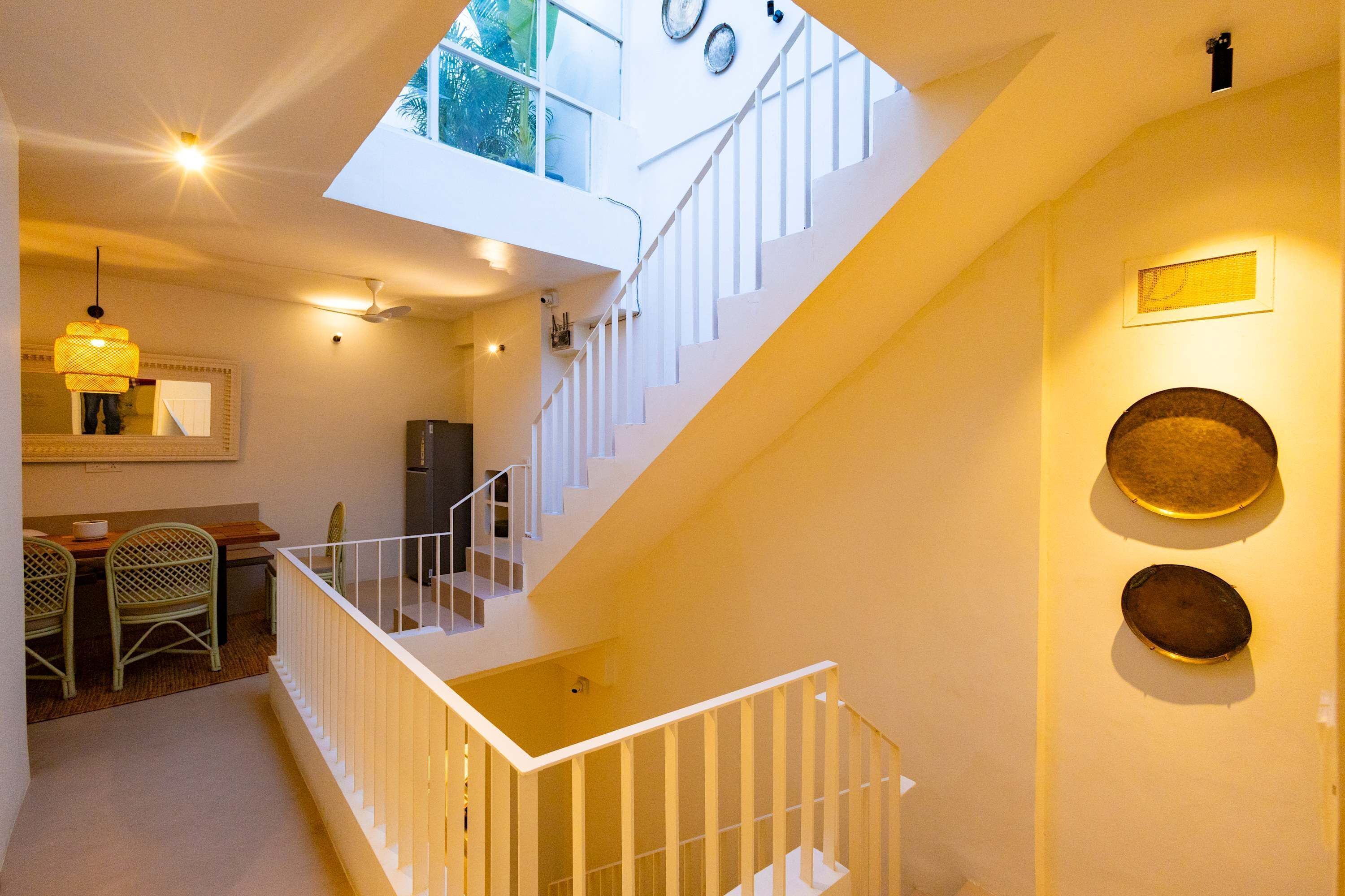 Un intérieur moderne comprenant un escalier, un coin repas et une cuisine.
