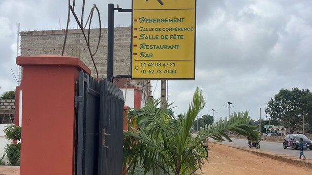 A yellow sign for Hotel Rio with amenities listed, including a conference room, a party room, a restaurant, and a bar. - RIO RÉSIDENCE  (Ouidah)