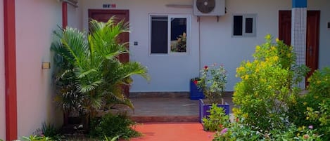 Un edificio de dos pisos con un sendero rojo que lleva a la entrada.