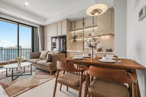 A modern apartment with a dining area, kitchen, and a balcony with a city view. - Brayen by Kozystay - Tebet (South Jakarta)