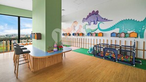 A children's play area with a dinosaur mural, a playhouse, and a ball pit. - Brayen by Kozystay - Tebet (South Jakarta)