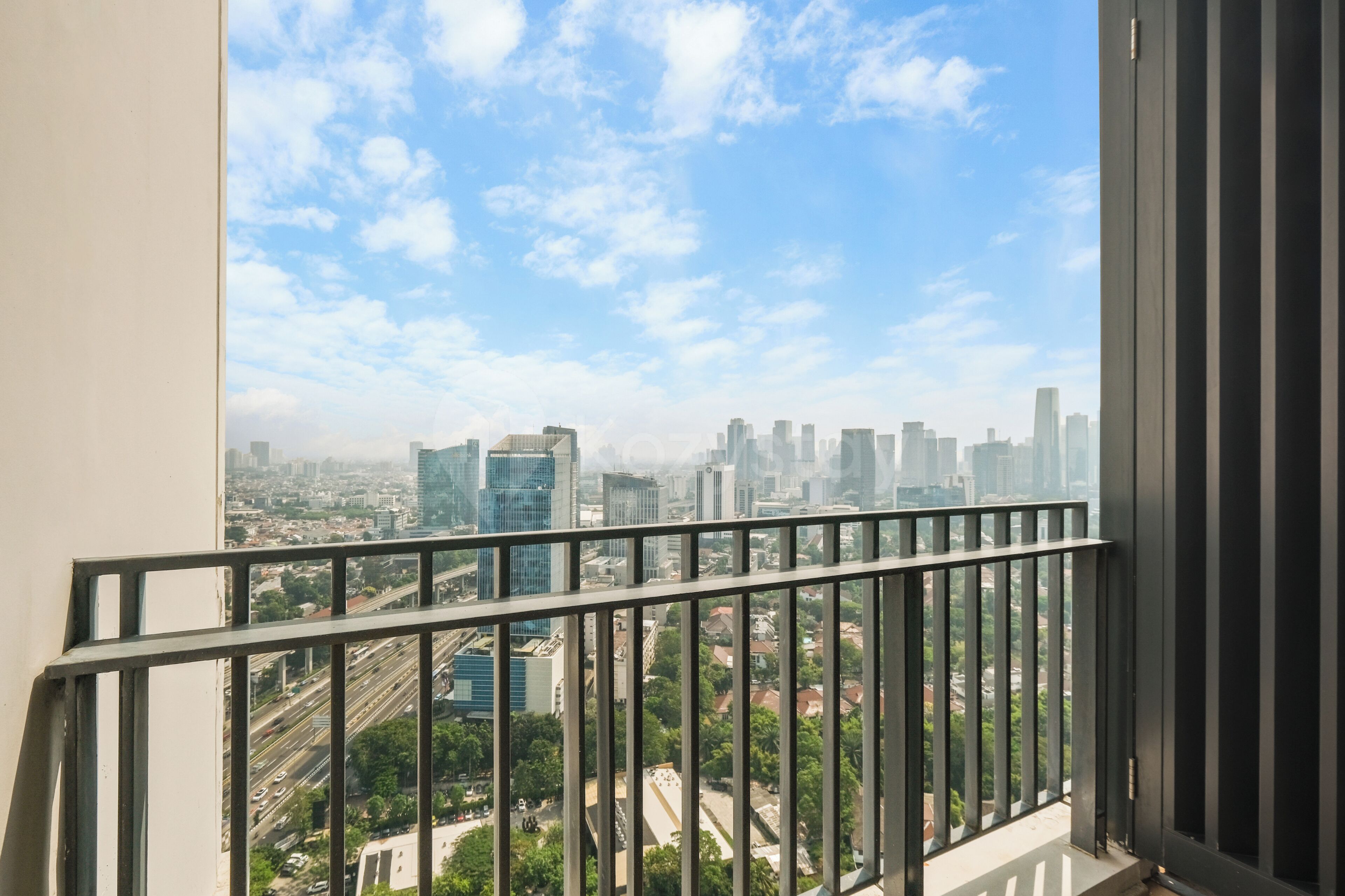 Un balcon offrant une vue sur le paysage urbain, avec ses bâtiments et ses rues.