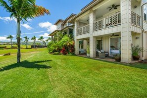 A two-story house with a covered porch, outdoor seating, and a well-maintained lawn. - Pili Mai 6F by Alekona Kauai - 2BR Condo access to fitness (Koloa)