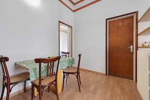 A dining area with a table, chairs, and a wooden door. - Casa Maderno: steps from the Lake (Toscolano Maderno)