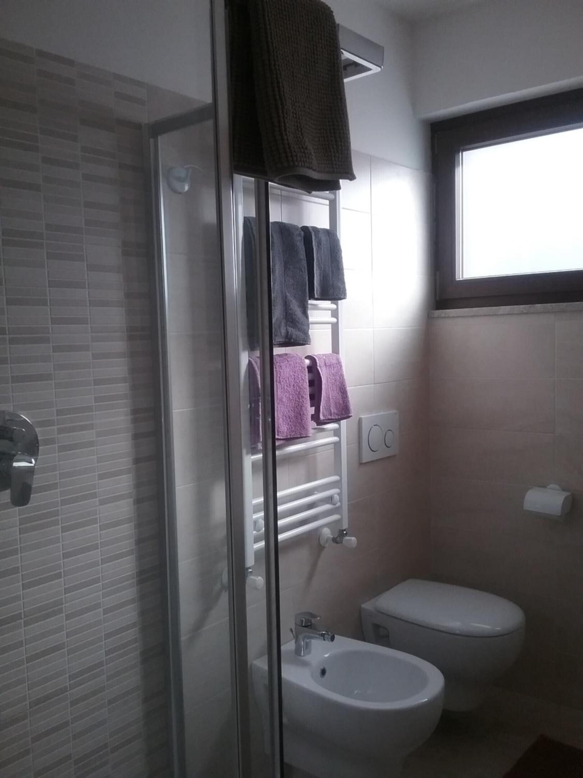 Une salle de bain avec une douche à parois de verre, un lavabo blanc et des toilettes.