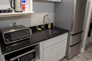 A kitchenette with a toaster, a sink, and a stainless steel refrigerator. - Casa Dora Summer Oasis (Bolivar Peninsula)