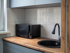 A kitchen with a microwave, a sink, and a window. - Comfort City Residence with beatiful vew (Almaty)