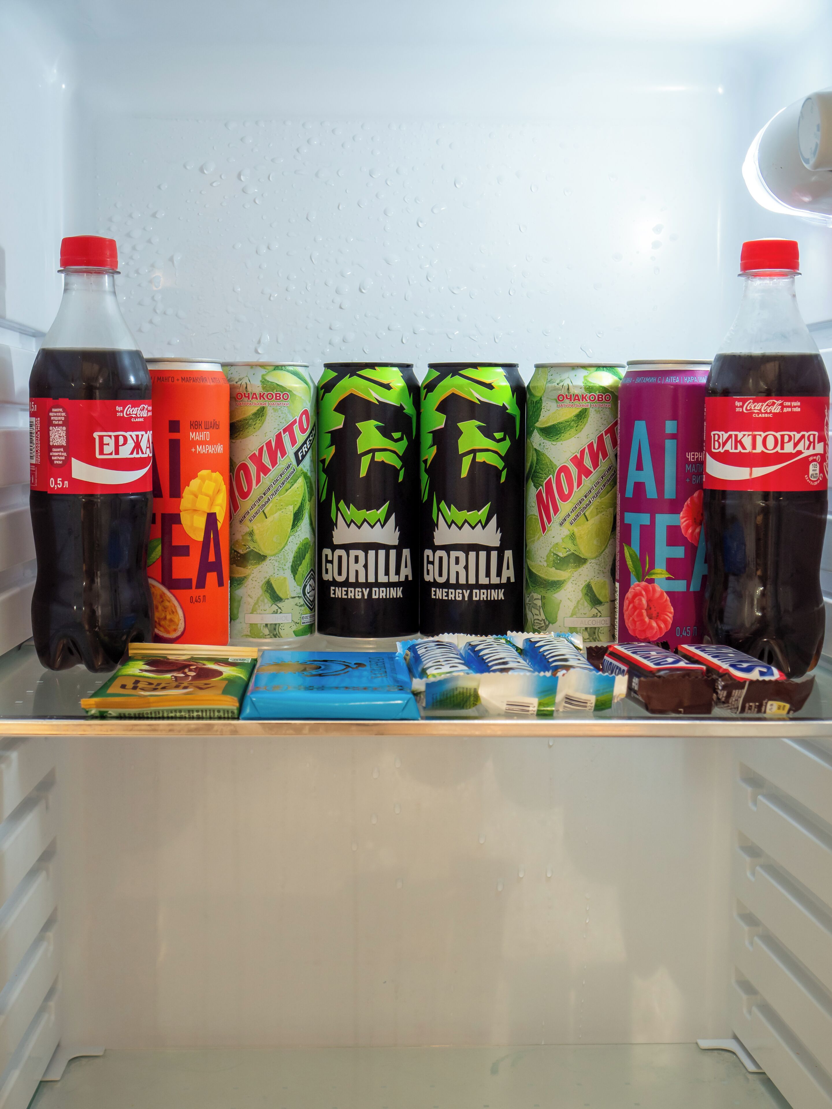Un frigorifero pieno di bevande e snack assortiti.