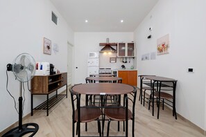 Une cuisine compacte avec un coin repas, comprenant un ventilateur, un four à micro-ondes et des placards.