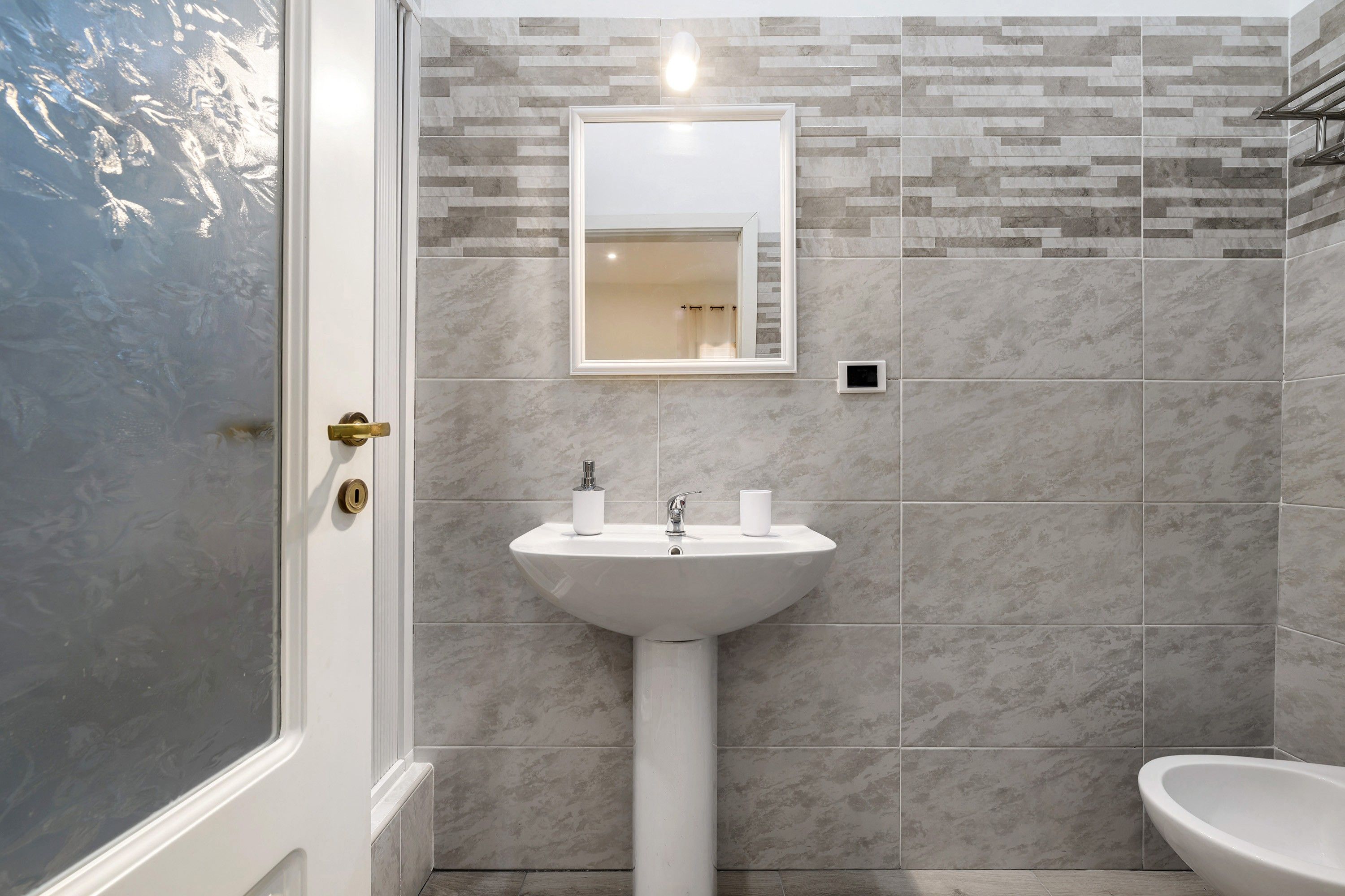 A bathroom with a shower, a sink, and a toilet.