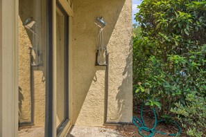 Ein Gebäudefassad mit strukturierter Wand und zwei außen angebrachten Duschköpfen.