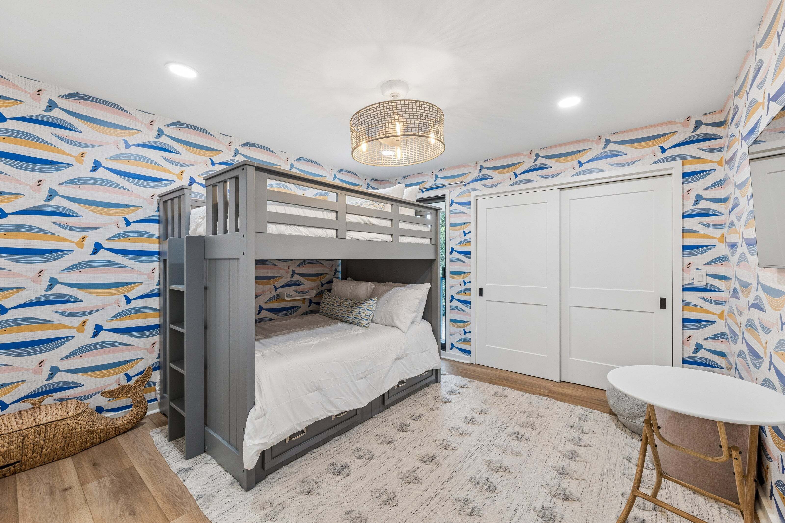 Une pièce avec un lit superposé, une petite table et une porte.
