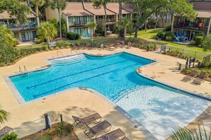 A swimming pool with multiple lanes, surrounded by lounge chairs and a fenced area. - 3BR Beachside Villa with Community Pool, Short Walk to the Beach (Hilton Head Island)