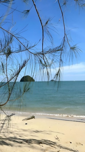 A beach with clear skies, calm water, and a small island in the distance. - A Coral Reefs Resort Langkawi (Langkawi)