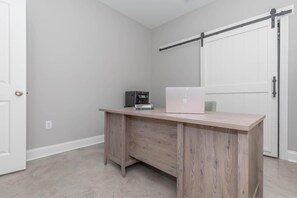 A room with a wooden desk, a white door, and a sliding barn door. - Spacious New Home 3BR/2BA Remote-Work Ready Dogs ok, fenced yard Near Lafayette (Duson)