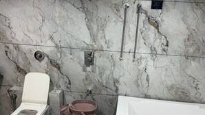 A bathroom with a toilet, bidet, and bathtub. - Hotel Civik (Ahmedabad)
