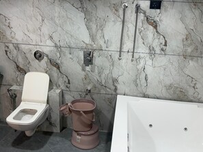 A bathroom with a toilet, bidet, and bathtub. - Hotel Civik (Ahmedabad)