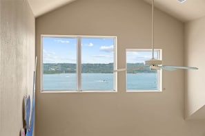 A room with two windows overlooking a body of water, a ceiling fan, and a partial view of a painting on the wall. - Club Yakov & 3bdr Lakefront (Hollister)