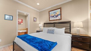 A hotel room with a bed, bedside tables, a nightstand, a mirror, and artwork on the walls. - Club Yakov & 3bdr Lakefront (Hollister)