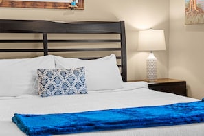 A neatly made bed with white linens, a blue patterned pillow, and a blue throw blanket. - Club Yakov & 3bdr Lakefront (Hollister)