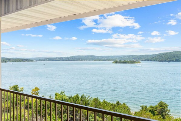 A view of a lake with a small island, a clear sky, and a balcony railing. - Club Yakov & 3bdr Lakefront (Hollister)