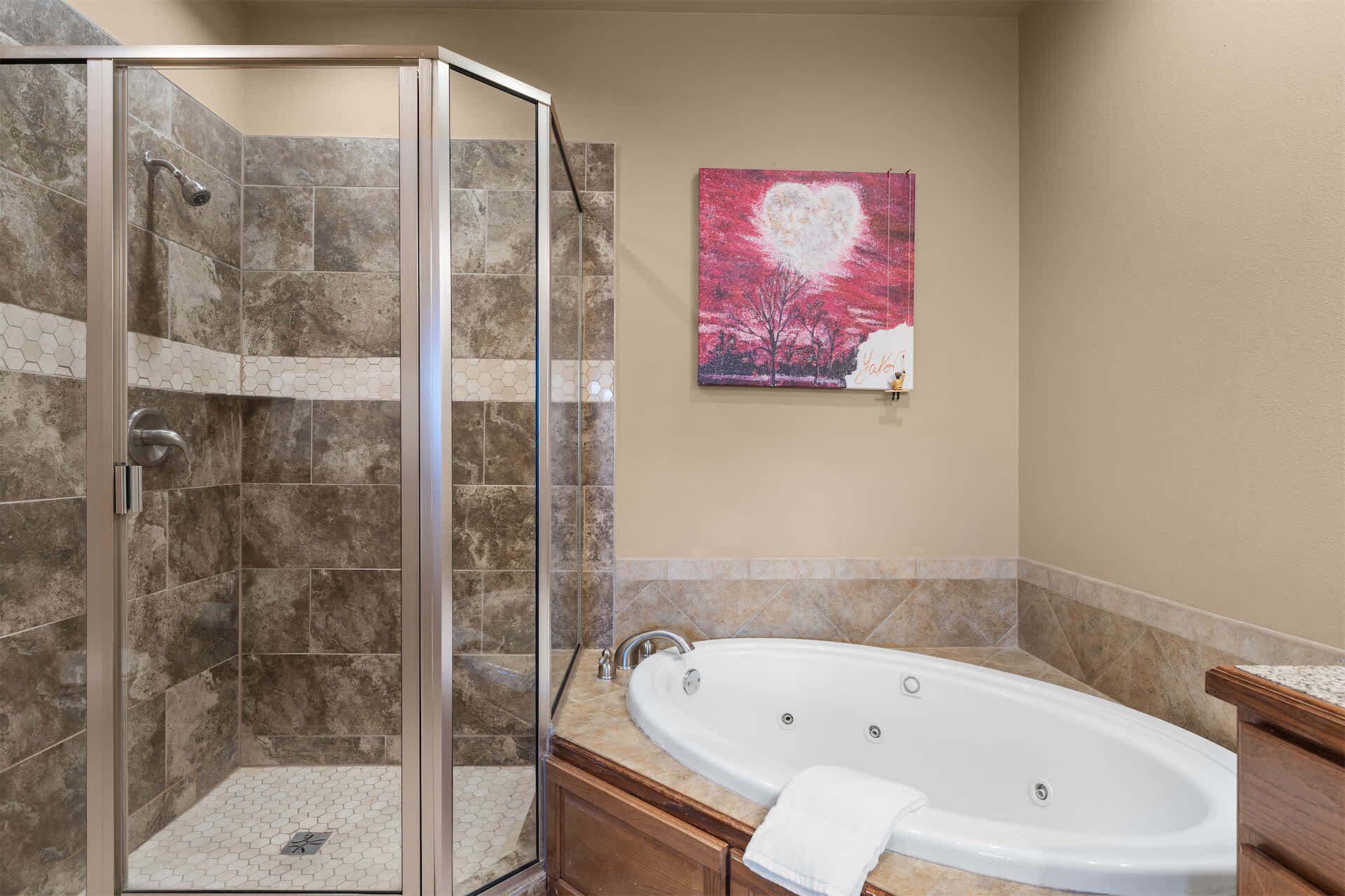 A bathroom with a glass-enclosed shower, a freestanding bathtub, and a tiled floor.