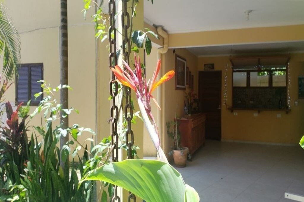 Um quarto com piso de azulejos, um armário de madeira e uma janela com persianas.