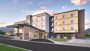 Een meerlaags hotel met een modern ontwerp, voorzien van een overdekte ingang en een parkeerplaats.